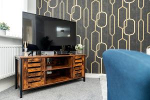a television on a wooden entertainment center in a living room at Eagle Drive - Humberston in Humberston
