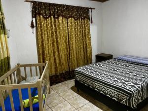 a bedroom with a bed and a crib and a window at DOÑA ROSA in Puerto Iguazú +31 photos
