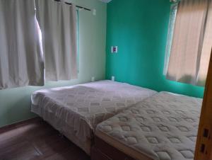 una camera da letto con un letto in una stanza con pareti verdi di Praia do Ervino SC a São Francisco do Sul