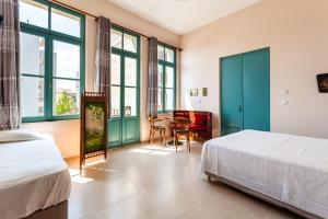 a bedroom with two beds and a table and chairs at Στούντιο Στη Στοά Βαρβουτσή#10 in Kalamata