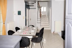 a dining room with a white table and black chairs at Beautiful village house in Metóchion