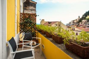 a balcony with chairs and potted plants on a building at Amalfi Luxury House in Amalfi