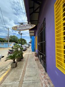 un edificio púrpura con un letrero para un restaurante en Casa Romano Hostel, en San Juan del Sur