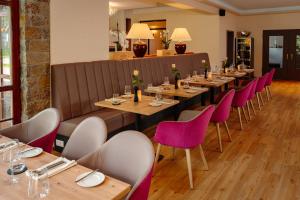 a row of tables in a restaurant with purple chairs at Hotel & Restaurant Lengefelder Warte in Anrode +56 photos