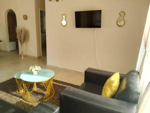 a living room with a couch and a table at Little Oasis Self Catering Cottage in Harare