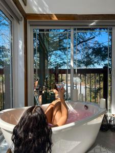 a woman laying in a bath tub with her feet up at LoveNestChalet - Hot tub & Fireplace - Warm, cozy & relaxing in Grenville-sur-la-Rouge