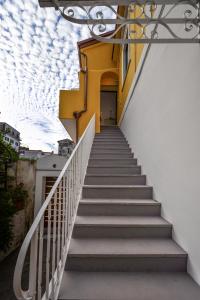 a stairway leading up to a yellow and white building at Amalfi Luxury House in Amalfi