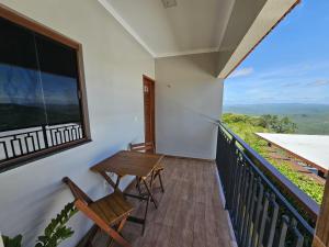 a balcony with chairs and a table and a window at Rancho Parati in Martins