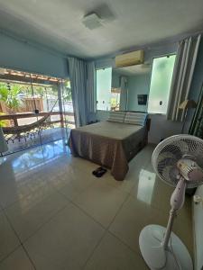 a bedroom with a bed and a fan on the floor at Casarão no Recanto de Itaipuaçu in Maricá +14 photos
