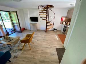 a spiral staircase in a living room with a table at Deni&Dino in Lohovo