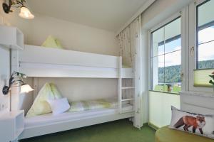 białe łóżko piętrowe w pokoju z oknem w obiekcie Gästehaus Herma w mieście Ramsau am Dachstein