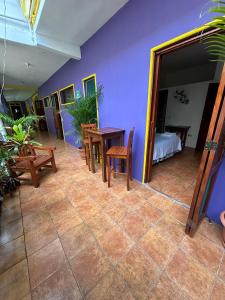 Una habitación con una mesa y sillas y un dormitorio. en Casa Romano Hostel, en San Juan del Sur