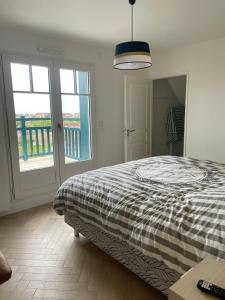 a bedroom with a bed with a checkered blanket at Villa 11 Cyrille et Vacances in Deauville