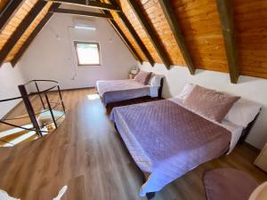 a bedroom with two beds and a wooden ceiling at Deni&Dino in Lohovo