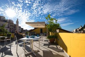 a patio with a table and umbrella on a roof at Amalfi Luxury House in Amalfi
