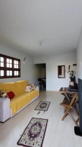 a living room with a yellow couch and a table at Hospedaria ideal in Uruguaiana