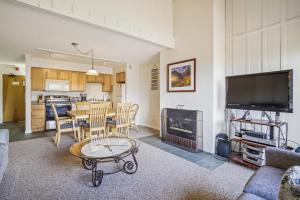 a living room with a table and a television and a kitchen at Three bedroom condo, Ski home Whiffletree E7 in Killington