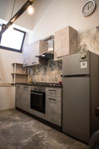 a kitchen with a refrigerator and a clock on the wall at Sweet Loft Ostia in Lido di Ostia