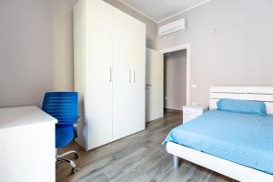 a bedroom with a bed and a blue chair at Relis rooms in Quartu SantʼElena