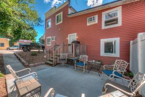 a red house with chairs and a table in front of it at Moonbeam Condo - Beautiful 2 Bedroom Stay by Beach in Pepin