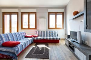 a living room with a couch and a tv at Relis rooms in Quartu SantʼElena
