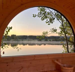 an arched window with a view of a lake at 'Swan' Lakeview Lodge in Bishampton