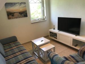 a living room with a couch and a tv at Sonnenwind in Prerow