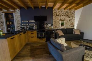 a kitchen and living room with a couch and a table at Le Petit Candie in Maisoncelles-en-Brie
