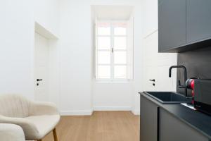 a kitchen with a sink and a chair and a window at TUDISI LUX SUITES by DOMINIUM in Dubrovnik