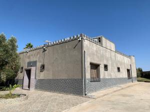 a large gray building with a door on the side at Villa avec piscine in Safi