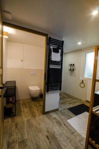 a bathroom with a toilet and a refrigerator with towels at Le Petit Candie in Maisoncelles-en-Brie