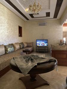 a living room with a couch and a tv at Villa avec piscine in Safi