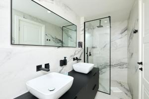 a white bathroom with a sink and a mirror at TUDISI LUX SUITES by DOMINIUM in Dubrovnik