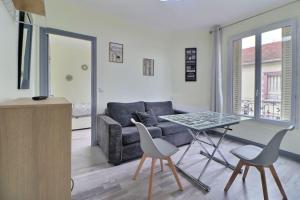 un soggiorno con un divano, un tavolo e delle sedie di Logement au pied de la gare ad Aulnay-sous-Bois