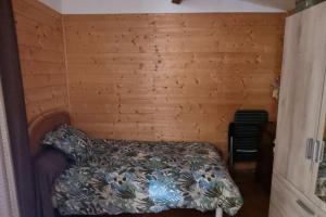 a bedroom with a bed in a wooden wall at Maisonnette chez l'habitant in La Ciotat