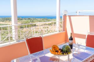 a table with a bowl of fruit and a bottle of wine at La Dimora in Lixouri