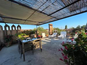eine Terrasse mit Tisch und Stühlen unter einer Pergola in der Unterkunft Giudecca Palanca 664 in Venedig