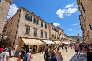 a group of people walking down a street with buildings at TUDISI LUX SUITES by DOMINIUM in Dubrovnik +17 photos