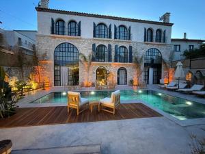 a house with a swimming pool in front of a building at Rhea Alaçatı Boutique Hotel in Alaçatı