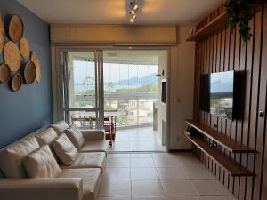 a living room with a couch and a sliding glass door at Nautilus Home Club - Penha - SC in Penha