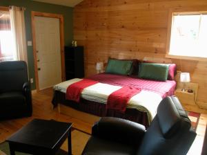 a bedroom with a bed and two chairs in it at Waterview B&B in Pictou