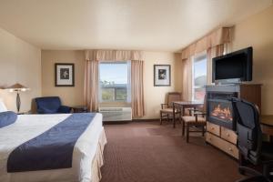 a hotel room with a bed and a flat screen tv at Grande Cache Inn & Suites in Grande Cache