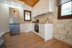 eine Küche mit weißen Geräten und Holzböden in der Unterkunft Ikarion Village Home by RentalsPro- Fourka Halkidiki in Fourka