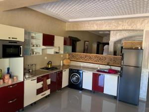 a kitchen with a refrigerator and a washing machine at Villa avec piscine in Safi