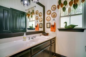 a bathroom with a sink and a mirror at Elegant Baton Rouge Home with Yard about 3 Mi to LSU! in Baton Rouge +25 photos