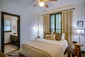 a bedroom with a bed with a ceiling fan and a window at Elegant Baton Rouge Home with Yard about 3 Mi to LSU! in Baton Rouge