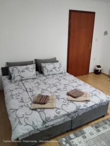 a bedroom with a bed with two towels on it at Topsan Prenociste Rooms in Sokolac
