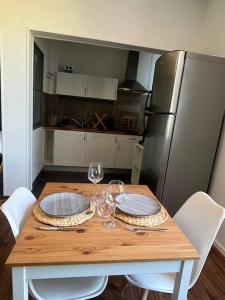 a wooden table with two wine glasses and a refrigerator at Le petit jardin de Bellune in Niort +5 photos