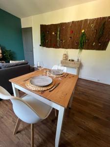 a dining room table with wine glasses on it at Le petit jardin de Bellune in Niort