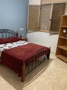 a bedroom with a bed with a red comforter at Villa avec piscine in Safi +13 photos